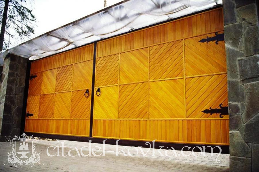 Откатные кованые ворота с деревянными панелями фотография 1
